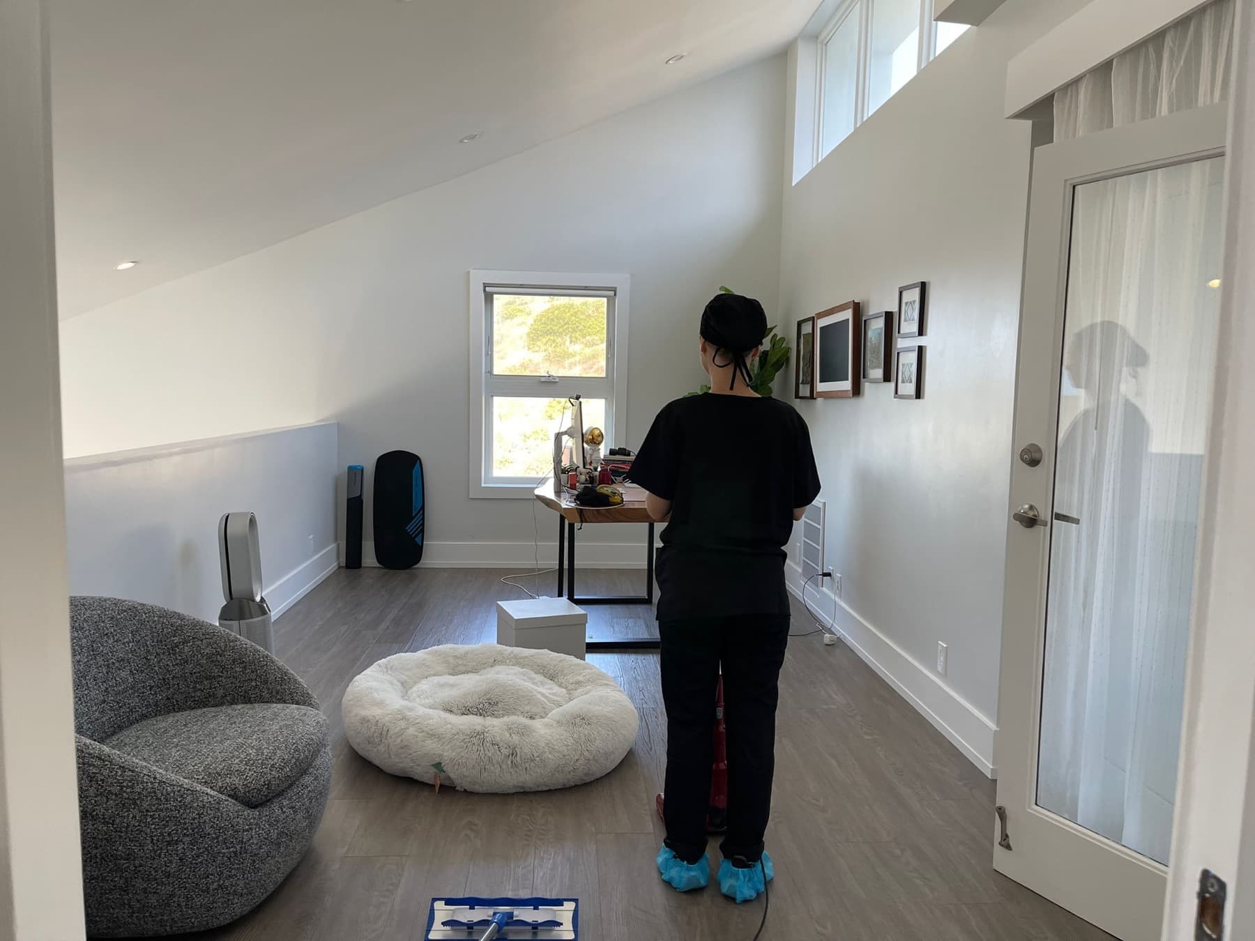 Mopping the floor of a light-filled loft room